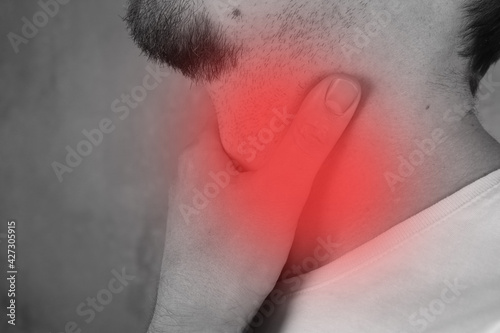 Man with sore throat, black and white photo with red pain area