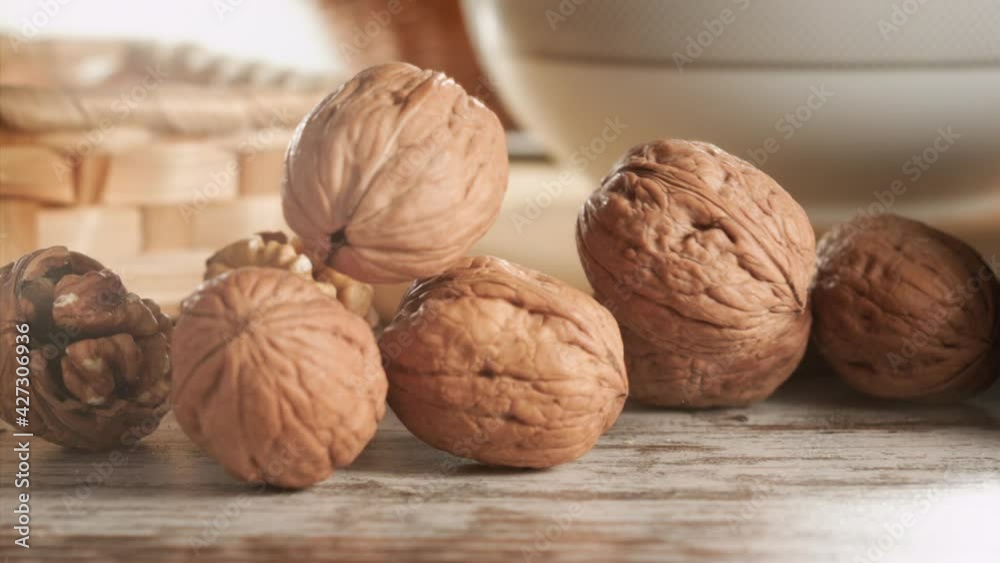 Walnuts falling on a wooden table in slow motion Walnuts falling on a wooden table in slow motion