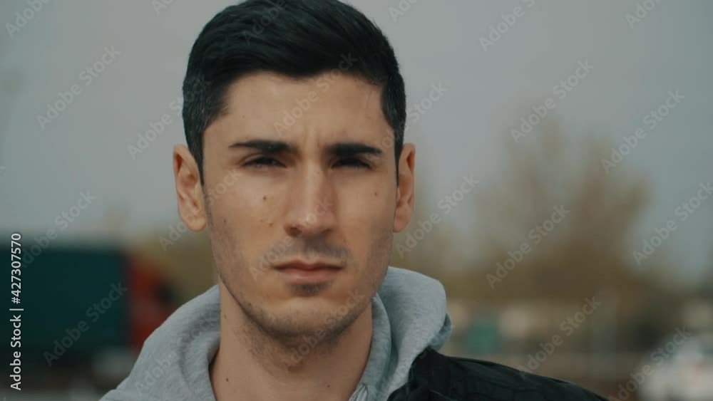 hombre caminando de frente, hombre de cabello negro caminando de frente, hombre con ojos negros  y pelo corto mirando a la cámara