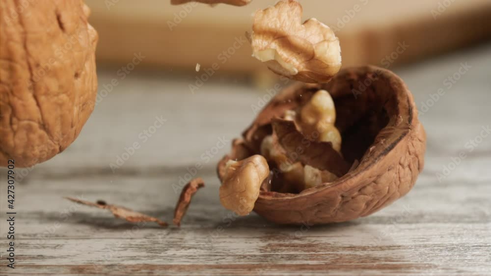 Walnut falling and cracking on close-up on a wooden table