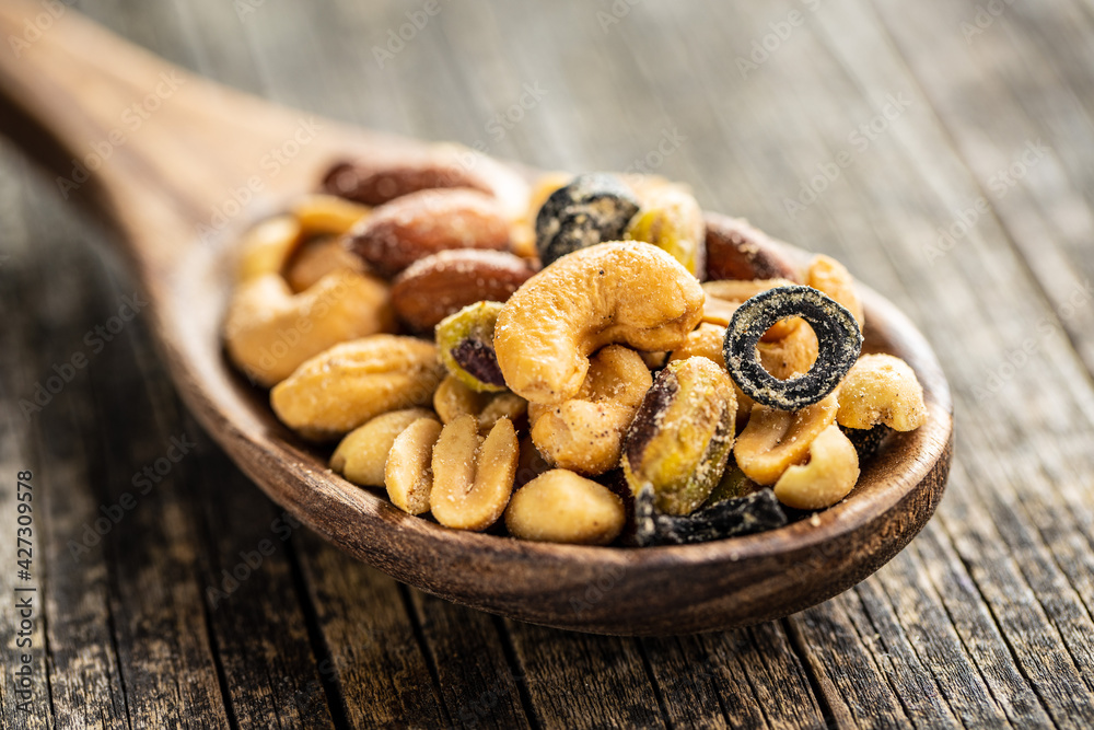 Mix of salted nuts in wooden spoon. Mix of salted nuts in wooden spoon.