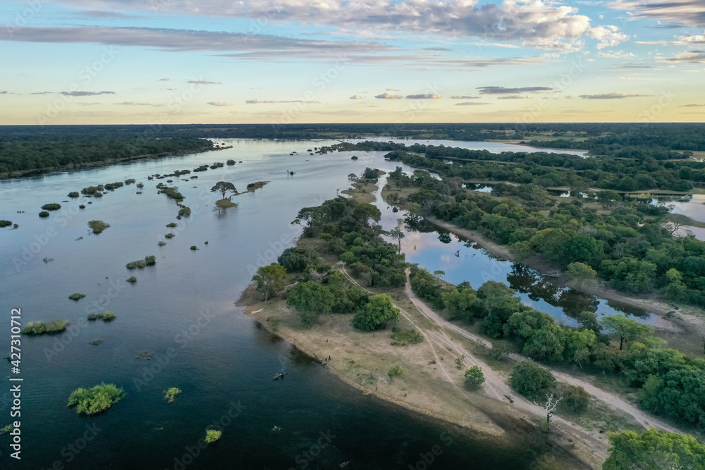 Wide aerial view of the Zambezi river in Zambia in flood at sunset with fishermen in their boat.