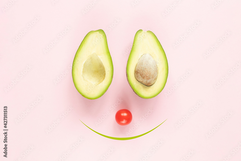 Vegeterian creative smilling concept: two halfs of avocado with and without seed and tomato on pink background. Vegeterian creative smilling concept: two halfs of avocado with and without seed and tomato on pink background.