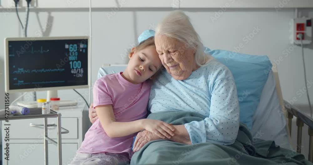 Upset little girl visiting her grandmother at hospital ward Upset little girl visiting her grandmother at hospital ward