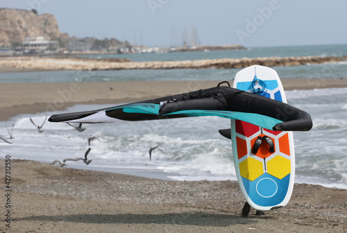 rider walks with foilboard comet, board and hydrofoil, on the beach photo