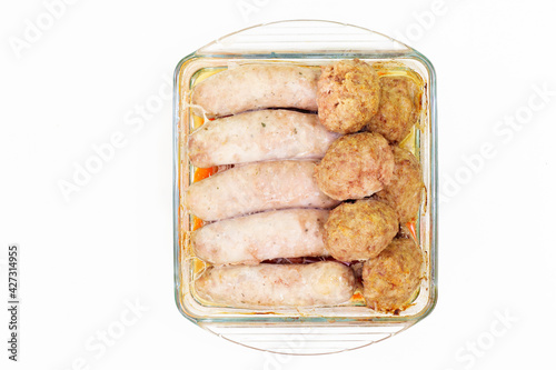 Roasted sausages and meatballs. Hot and spicy homemade meat food roasted in oven. Isolated on white background. Top view, flat lay photo