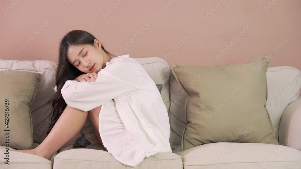 Lonely woman sit on sofa at home. Cute girl sleep in her room