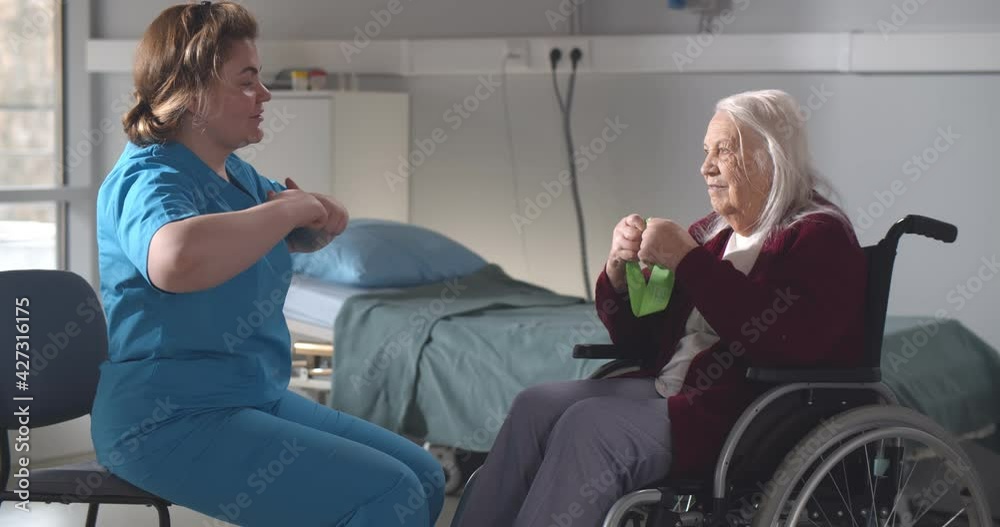 Senior woman with disability in wheelchair doing recovery exercise with therapist. Senior woman with disability in wheelchair doing recovery exercise with therapist.