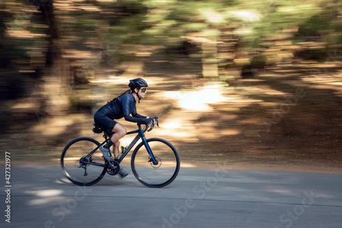 Mujer en bicicleta de pista en una carretera en medio del bosque. concepto de deporte al aire libre.  photo