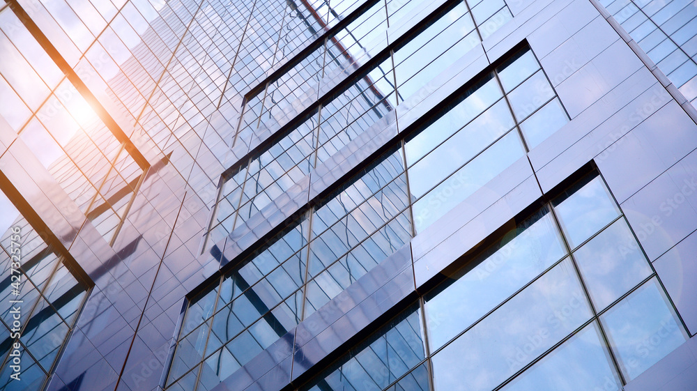 Obraz premium Glass clad facade of a modern building covered in reflective plate glass.
