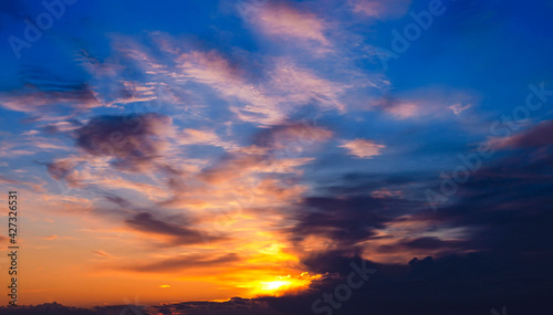 A beautiful photo of a gorgeous spring sunset sky with clouds in shades of orange and blue. Beautiful background for your design, wallpaper, screensaver, site. Great for printing on poster © Алла Пашкова
