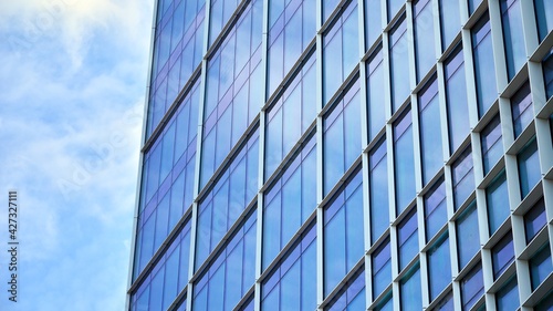 Glass clad facade of a modern building covered in reflective plate glass.