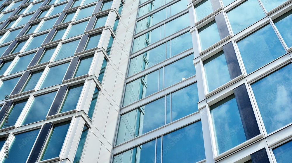Glass clad facade of a modern building covered in reflective plate glass. Glass clad facade of a modern building covered in reflective plate glass.