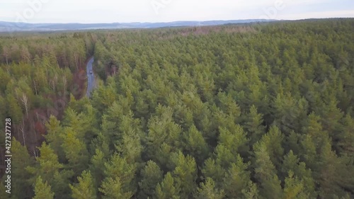 Car driving through a forest street in bavaria, topdown follower drone photo