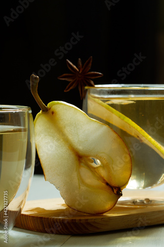 Pear cider, a carbonated low-alcohol refreshing drink. Close-up, vertical, dark background, contrast photo