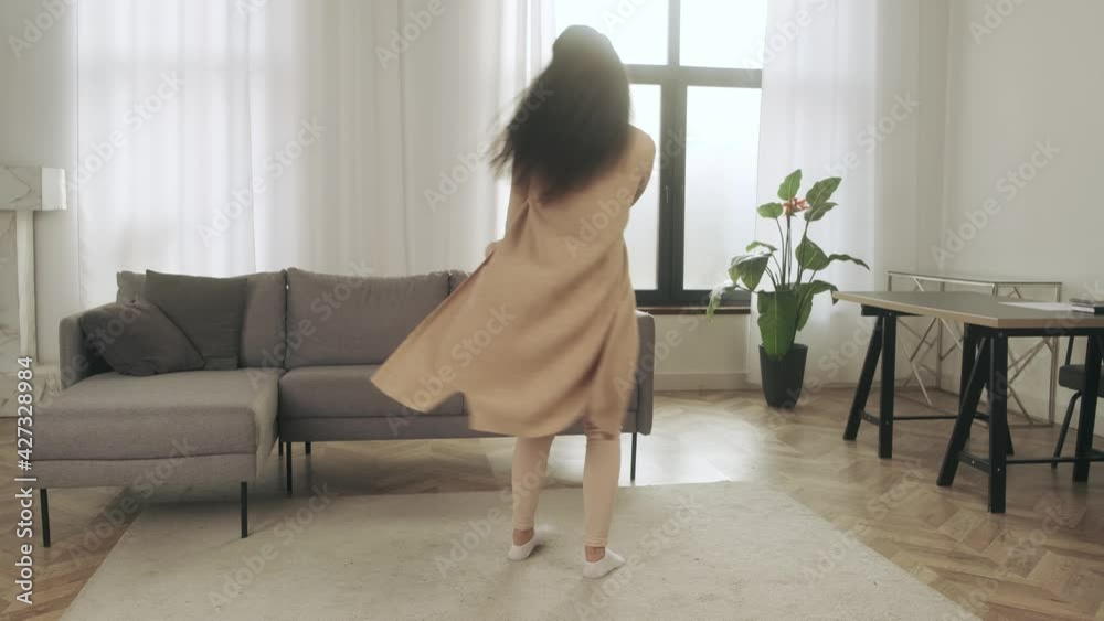 Adult woman dancing at home during quarantine with four year old daughter. Happy mother and small daughter having fun jumping indoors Adult woman dancing at home during quarantine with four year old daughter. Happy mother and small daughter having fun jumping indoors