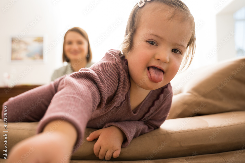 Girl with down syndrome stretching to the camera and holding makeup brush Girl with down syndrome stretching to the camera and holding makeup brush