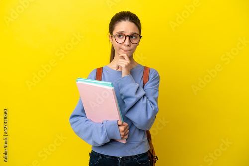 Student kid woman over isolated yellow background having doubts and thinking