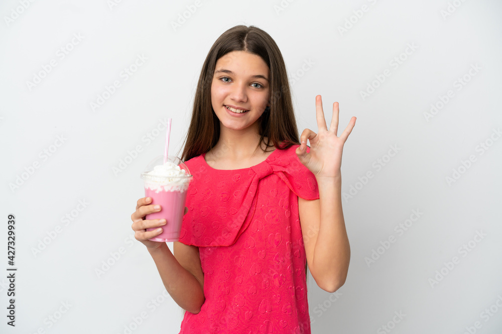 Little girl with strawberry milkshake over isolated white background showing ok sign with fingers Little girl with strawberry milkshake over isolated white background showing ok sign with fingers