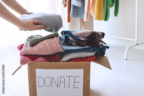 Slika na platnu Woman holding Clothes with Donate Box In her room, Donation Concept