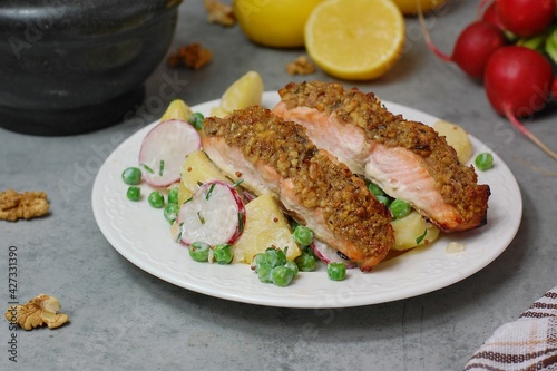 Fresh potato salad with peas, radish and roasted salmon with walnut crust