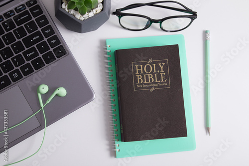 Holy Bible and laptop with headphones. Bible study, worship online concept