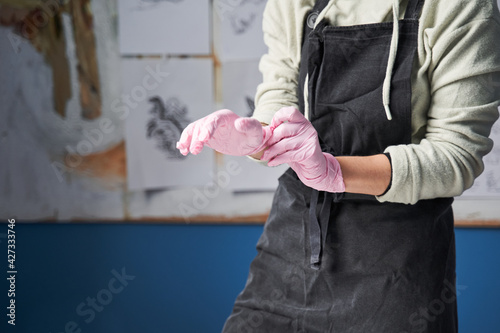 Artist putting on a protective gloves while preparing to the tattoo session