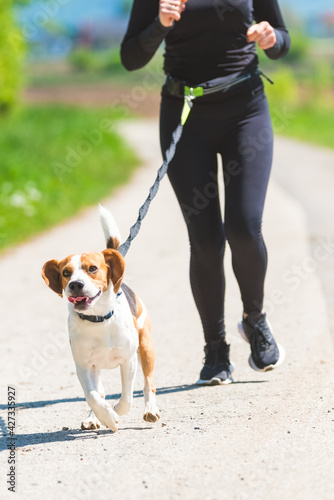 Girl running with dog outdoors in nature on road © Przemyslaw Iciak