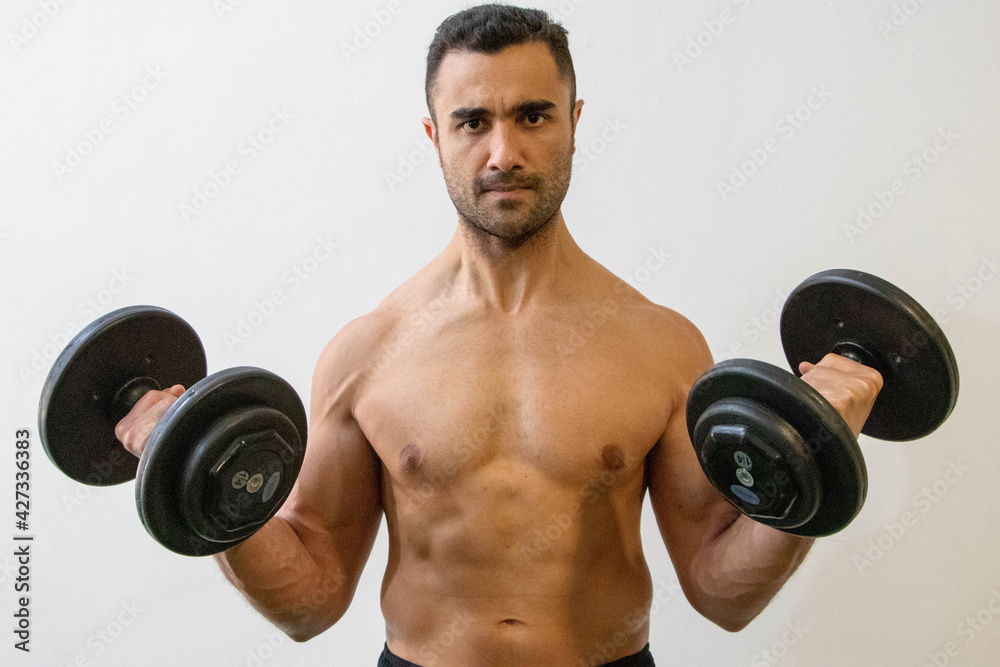 Jovem atleta, segurando halteres Jovem atleta, segurando halteres