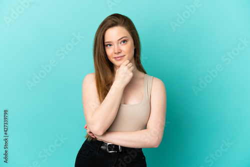 Teenager girl over isolated blue background thinking an idea while looking up © luismolinero