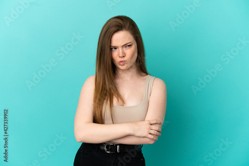 Teenager girl over isolated blue background with unhappy expression © luismolinero