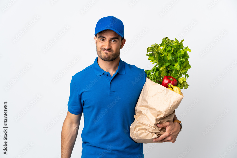 Delivery man with vegetables isolated on white background with sad expression Delivery man with vegetables isolated on white background with sad expression