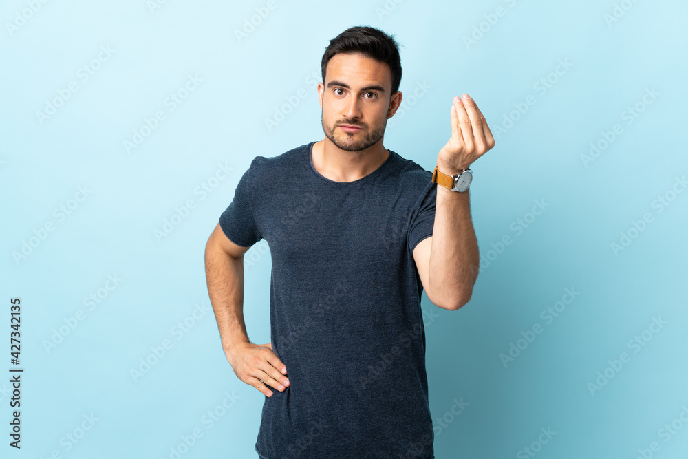 Fototapeta premium Young handsome man over isolated background making Italian gesture