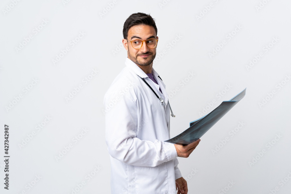 Young doctor man holding a radiography isolated on white background laughing Young doctor man holding a radiography isolated on white background laughing