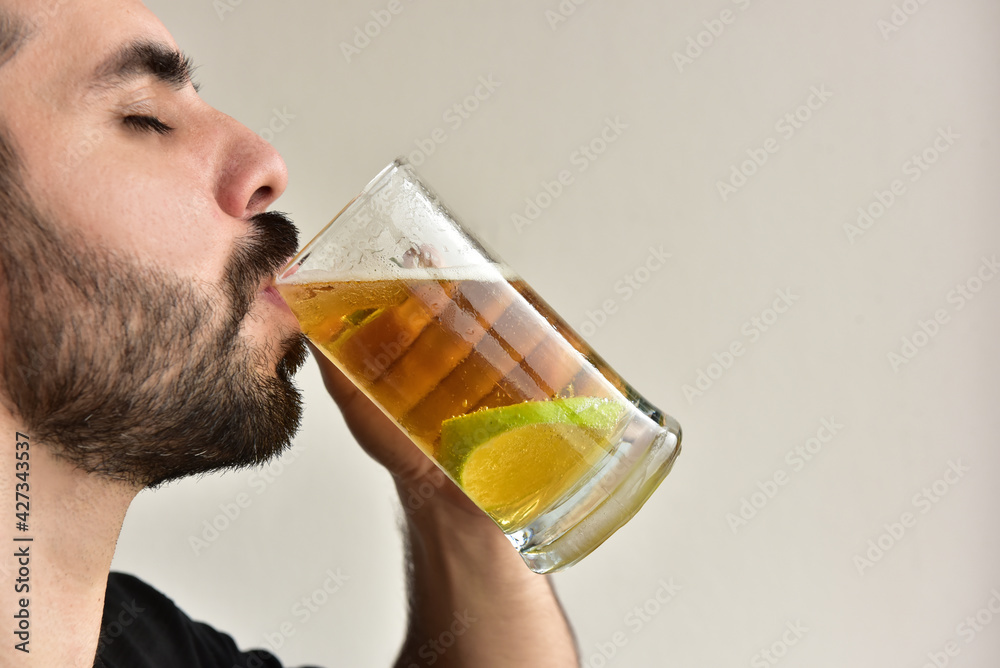 Bearded man drinking cold beer with lemon slice. Bearded man drinking cold beer with lemon slice.