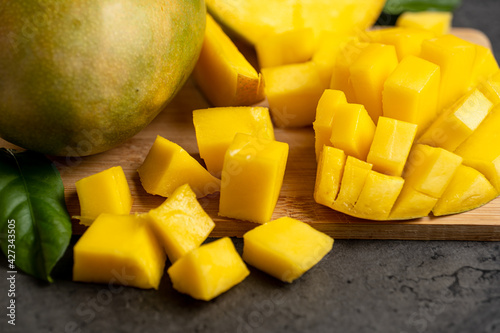 ripe mango cut into cubes on a dark gray background