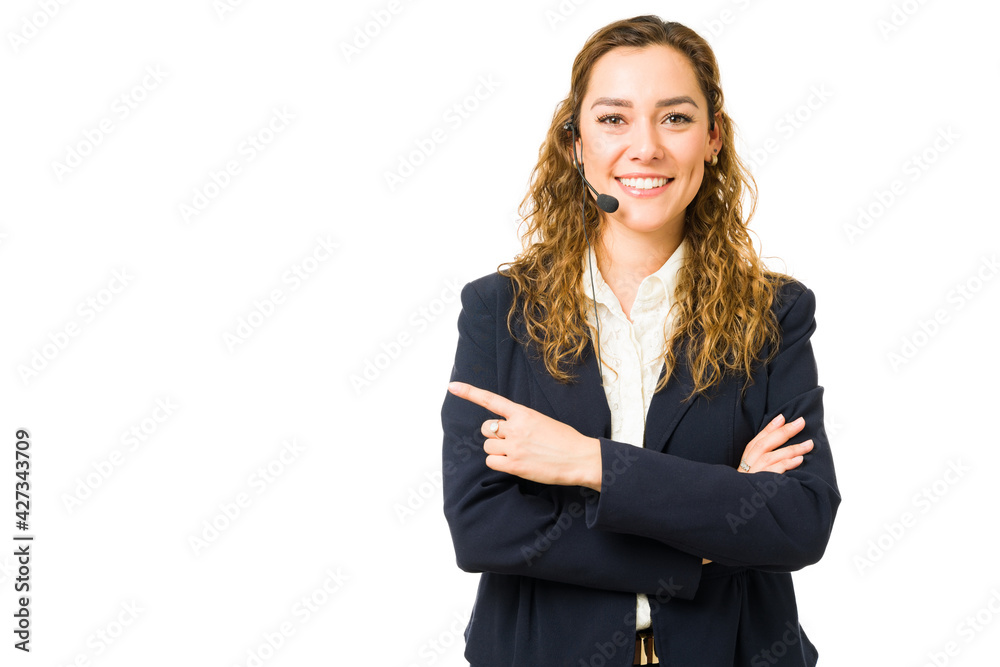 Portrait of a woman with a headset pointing to copy space Portrait of a woman with a headset pointing to copy space
