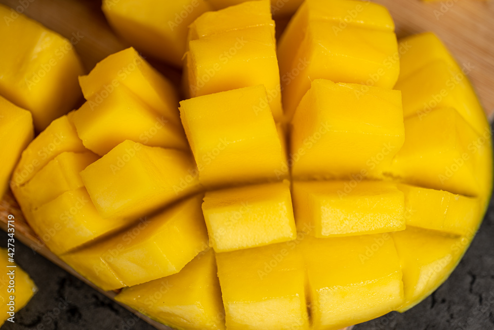 ripe mango cut into cubes on a dark gray background ripe mango cut into cubes on a dark gray background