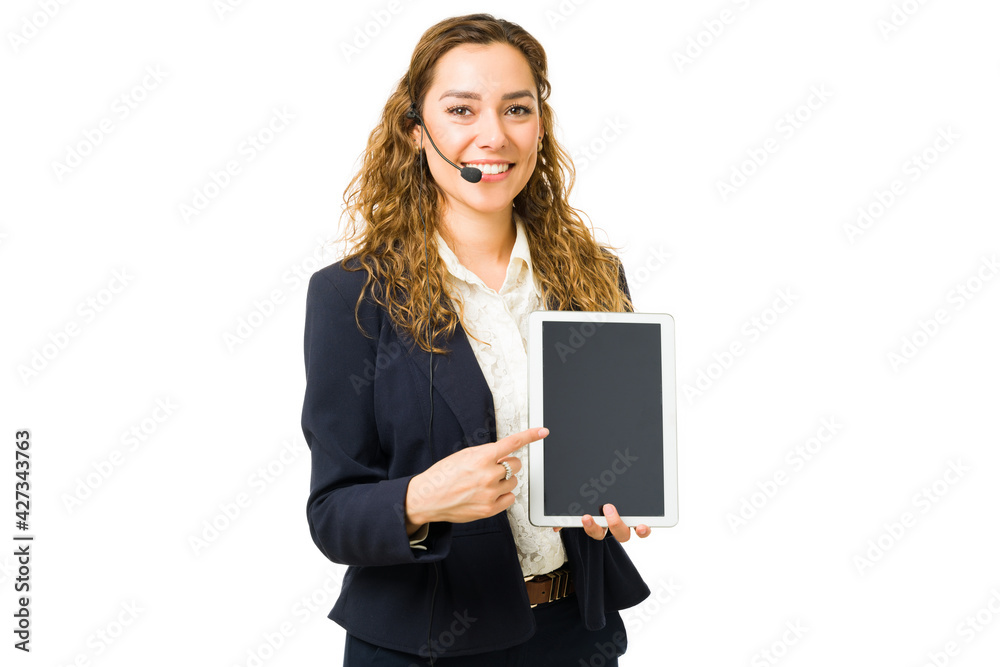 Attractive woman pointing to a blank screen of a tablet Attractive woman pointing to a blank screen of a tablet