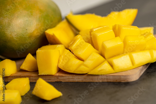 ripe mango cut into cubes on a dark gray background