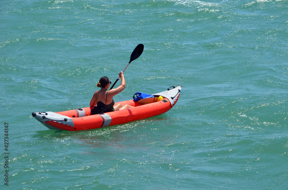 Woman paddling an inflatable canoe