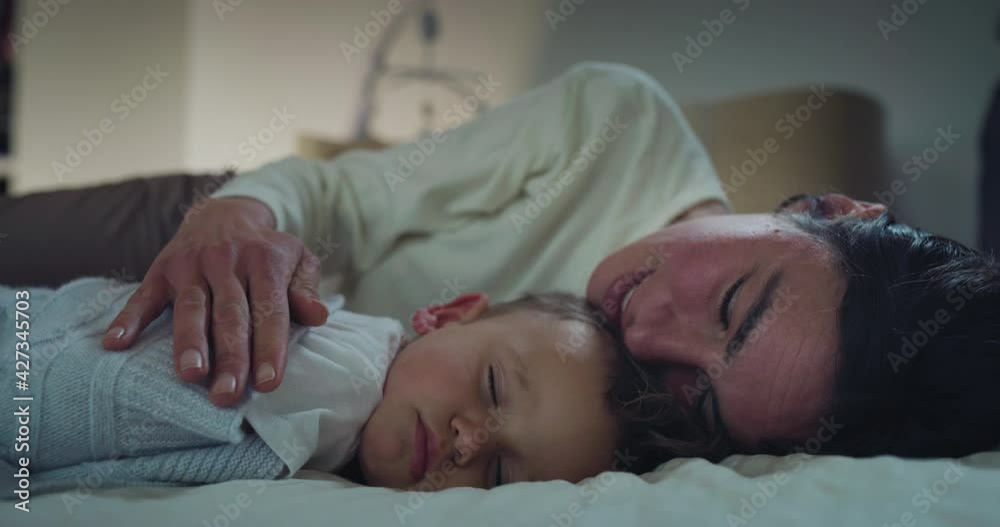 Authentic close up of mother is kissing her toddler baby boy while sleeping by day in crib with soft blanket in a nursery. Concept of family, comfort,care, love, sweet dreams, motherhood, childhood. Authentic close up of mother is kissing her toddler baby boy while sleeping by day in crib with soft blanket in a nursery. Concept of family, comfort,care, love, sweet dreams, motherhood, childhood.