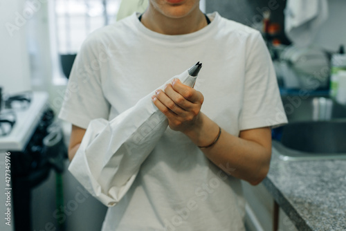 wonan holding white piping bag on the kitchen photo