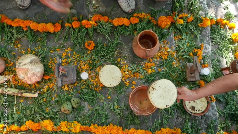 Mexican offering for the day of the dead, people setting up the altar with flower and food for the celebration. 