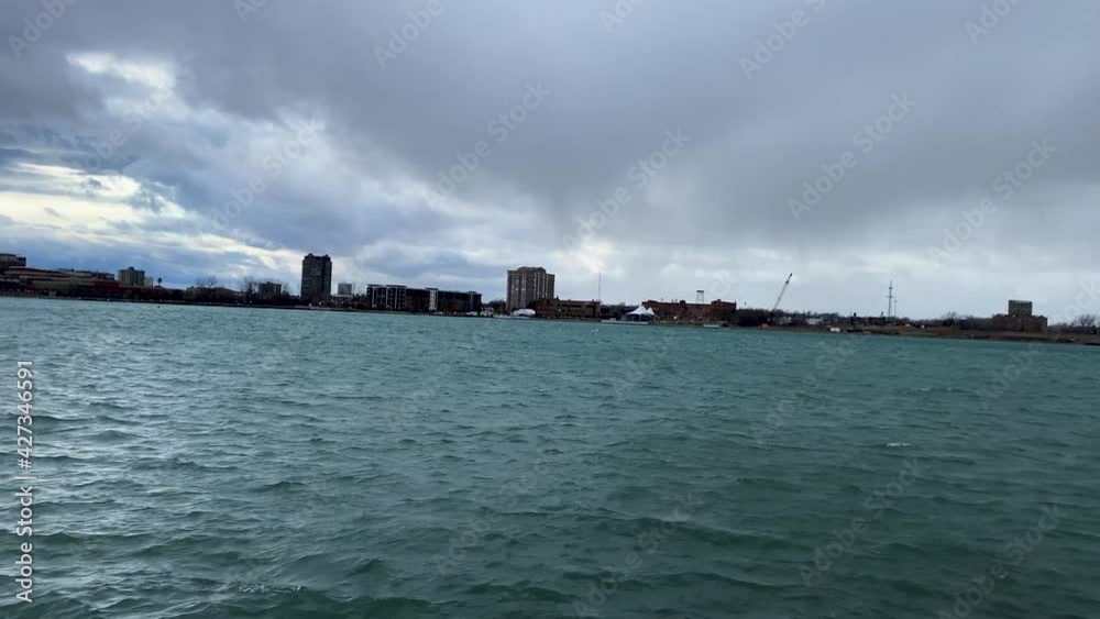 Pan shot of Detroit river waterfront with Detroit skyline in the background seen from belle isle island Pan shot of Detroit river waterfront with Detroit skyline in the background seen from belle isle island