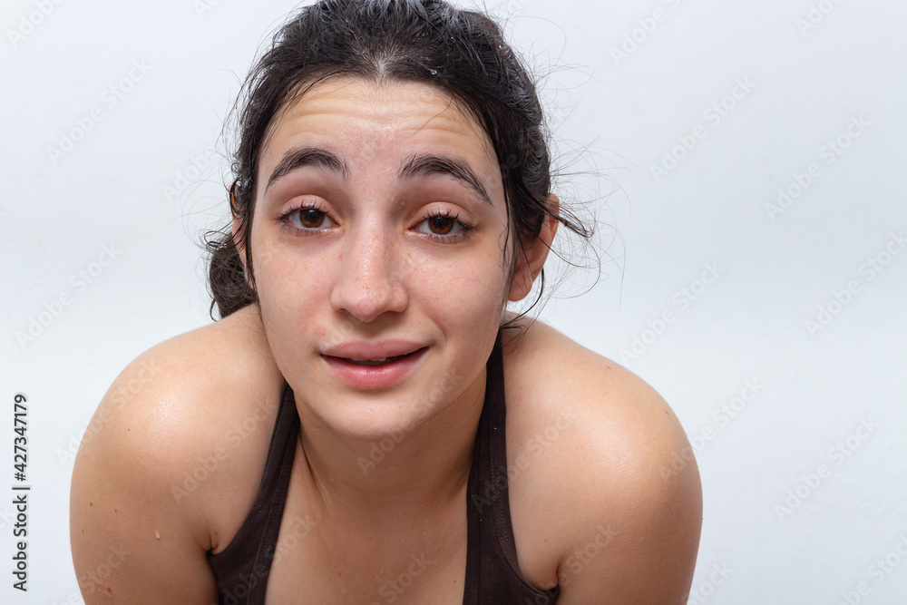 Brown tank top woman on white background with hair tied sweaty and tired Brown tank top woman on white background with hair tied sweaty and tired