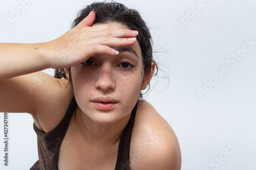 Brown tank top woman on white background with hair tied sweaty and tired