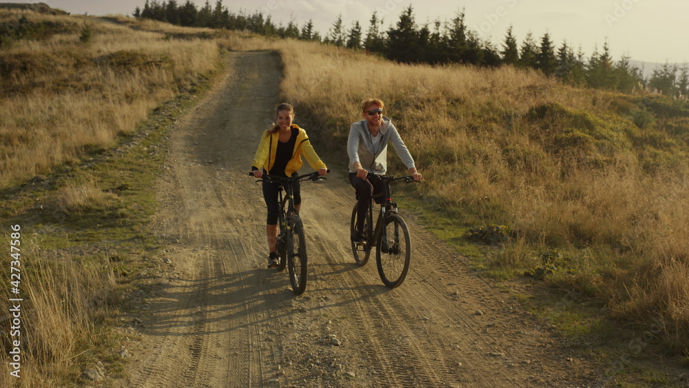 Athletes cycling on mountain bikes. Smiling man and woman talking together