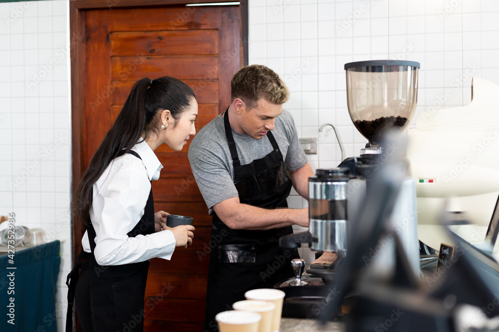 Barista cafe wearing apron and prepare coffee grinder pour at coffee shop with happy and smiling. Worker making coffee on steam espresso coffee machine Barista cafe wearing apron and prepare coffee grinder pour at coffee shop with happy and smiling. Worker making coffee on steam espresso coffee machine
