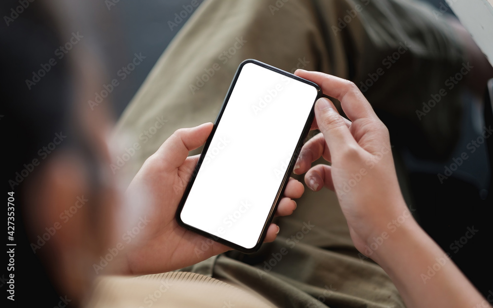 Top view Woman sitting and holding blank screen mock up mobile phone.